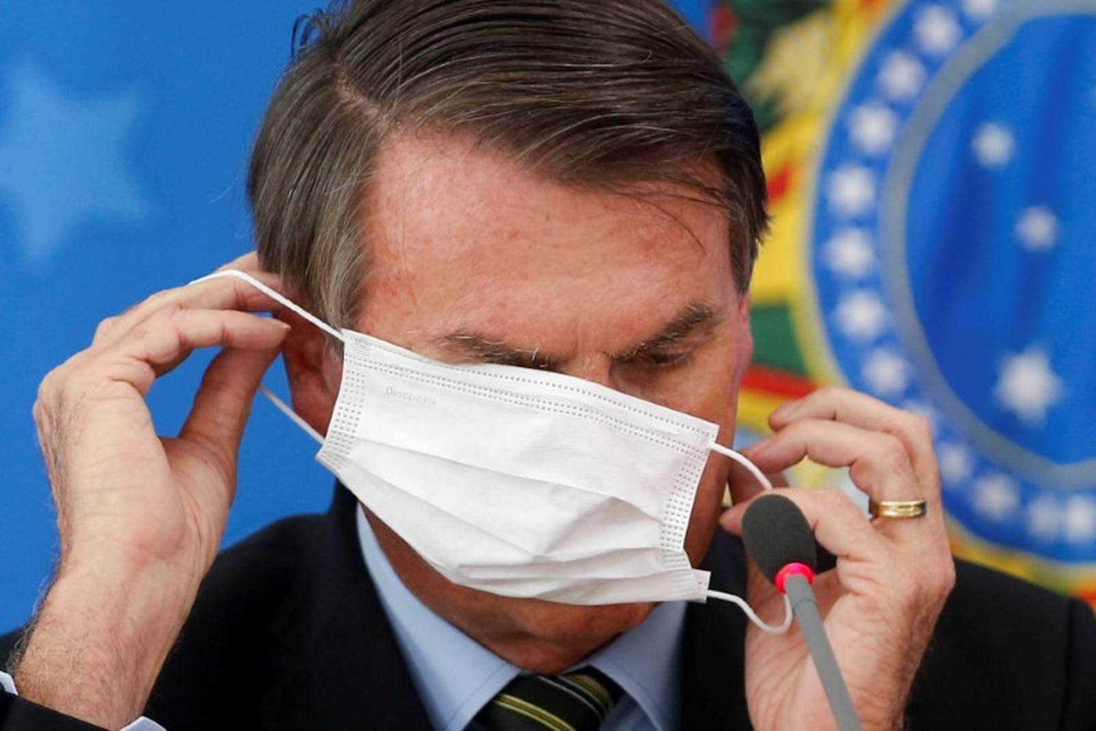 Bolsonaro colocou e retirou a máscara de proteção várias vezes durante a coletiva